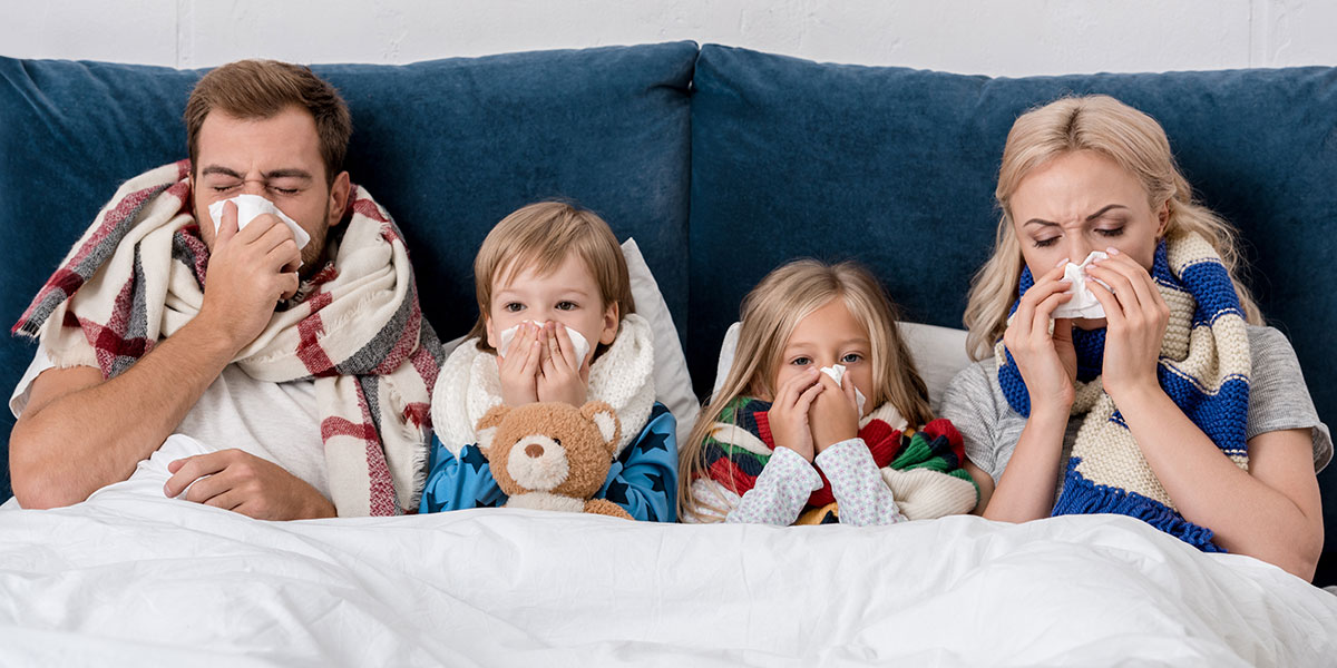 A family in bed together, sick with flu